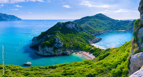 Beautiful summertime panoramic seascape. View of the cliff into the crystal clear azure sea bay and distant islands. Unique secluded beach. Agios Stefanos cape. Afionas. Corfu. Greece. © Sodel Vladyslav