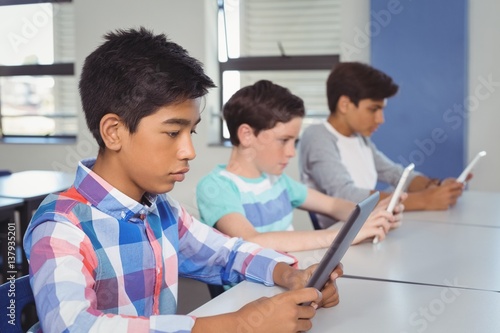 Students using digital tablet in classroom