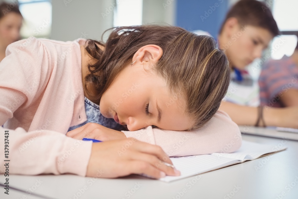 Tired schoolgirl sleeping in classroom Tired schoolgirl sleeping in classroom