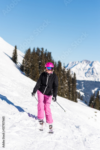 Female skier in front of trees and mountains