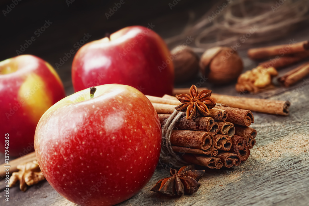 Fresh red and green apples, cinnamon sticks, ground cinnamon, anise stars, walnuts and hazelnuts on an old wooden background Fresh red and green apples, cinnamon sticks, ground cinnamon, anise stars, walnuts and hazelnuts on an old wooden background