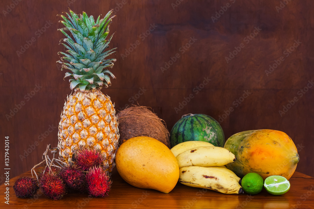 Tropical fruits on wooden table, close-up Tropical fruits on wooden table, close-up