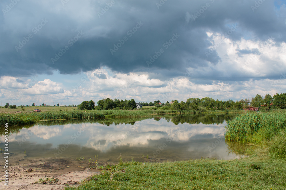 countryside landscape reflection in lake  with blue cloudy sky background