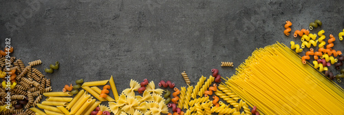 Various types of pasta - spaghetti, penne, fusilli, colored vegetables pasta.