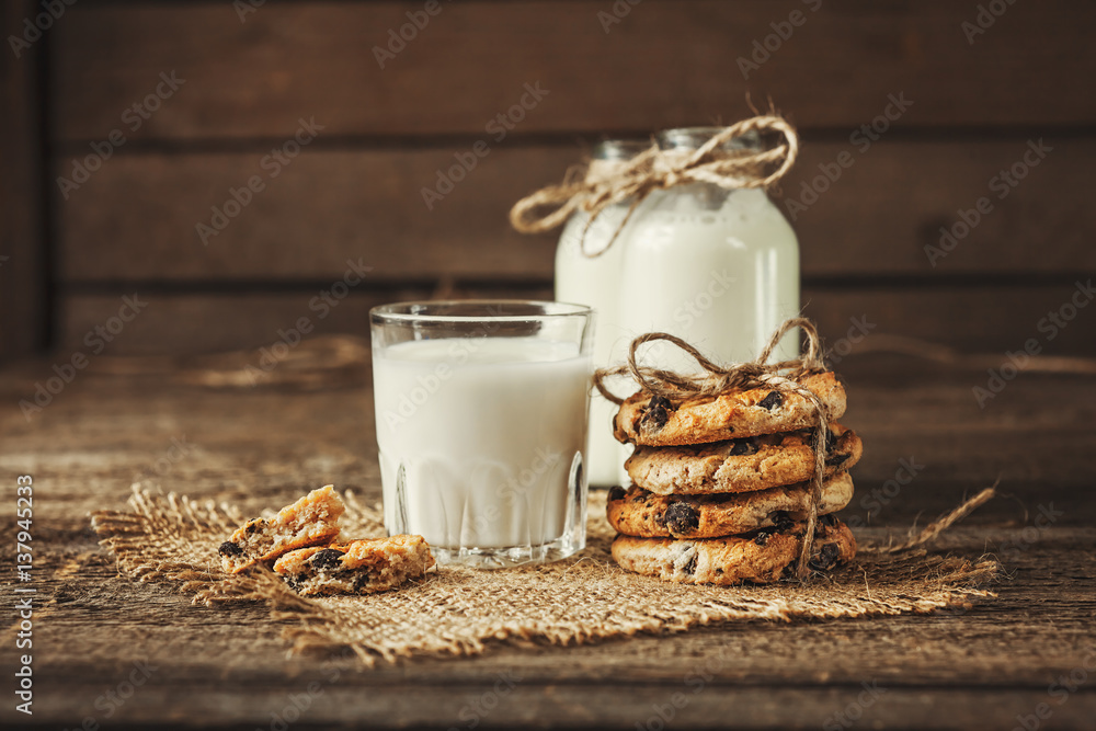 Milk beverages in glass bottles, crisp cookies with pomegranate seeds, vintage wooden background, rustic style - obrazy, fototapety, plakaty 