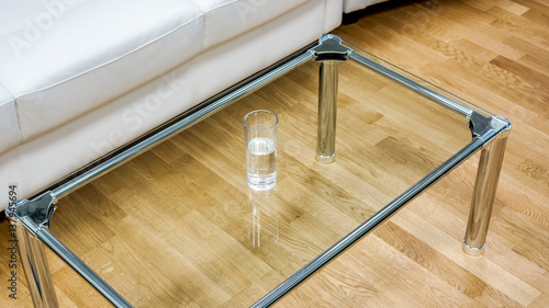 Clear glass small table against wooden floor on office reception