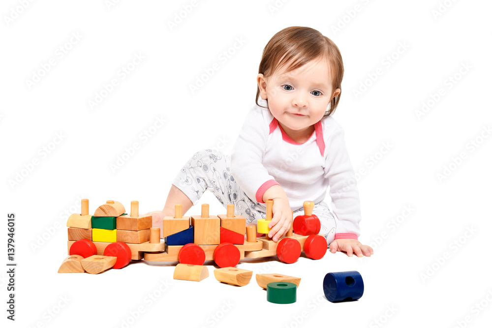 Cute little girl playing with wooden train, isolated on white background Cute little girl playing with wooden train, isolated on white background