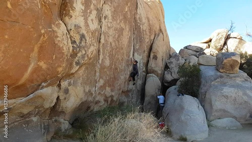 JOSHUA TREE, CALIFORNIA, UNITED STATES OF AMERICA, NOVEMBER 6 Woman learning to climb at huge rocks, in Joshua tree national park, in California, United states of america