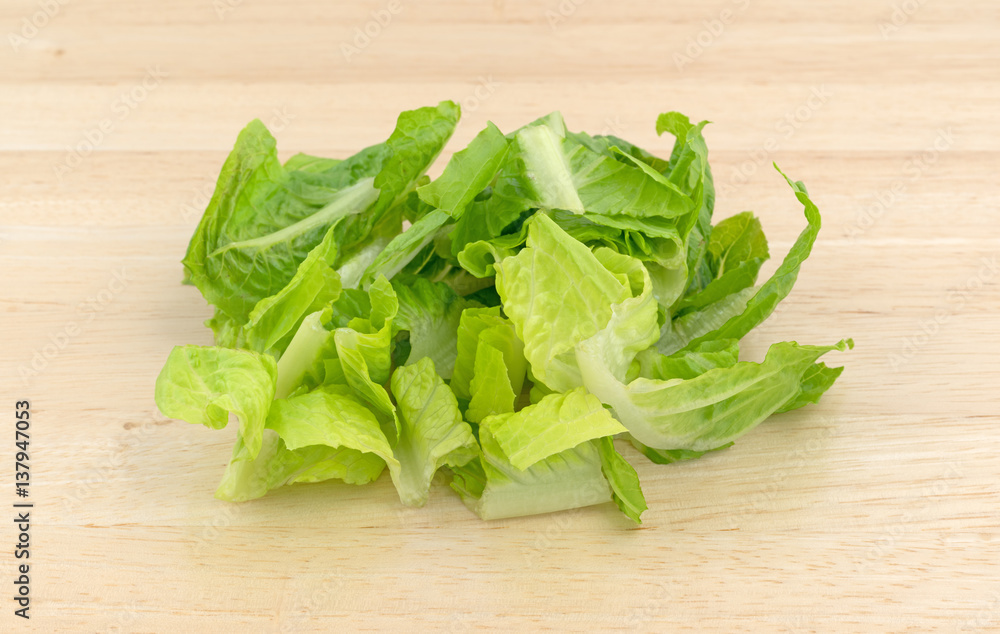 Romaine lettuce that has been sliced on wood cutting board. Romaine lettuce that has been sliced on wood cutting board.