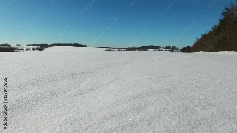 4K. Low flight and takeoff above snow fields in winter, aerial panoramic view. Winter land in the north. 4K. Low flight and takeoff above snow fields in winter, aerial panoramic view. Winter land in the north.