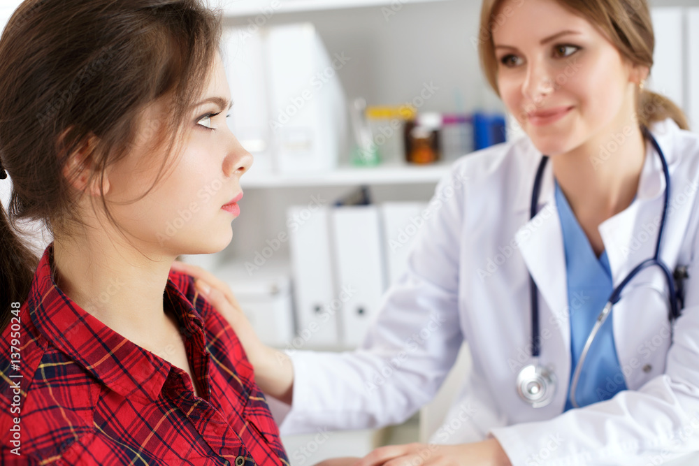 Friendly female doctor touching patient shoulder for encouragement Friendly female doctor touching patient shoulder for encouragement