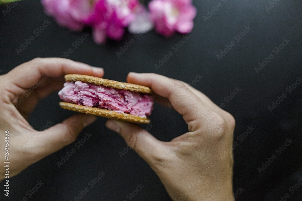 Hände halten Kirscheis-Sandwich mit Waffeln Hände halten Kirscheis-Sandwich mit Waffeln