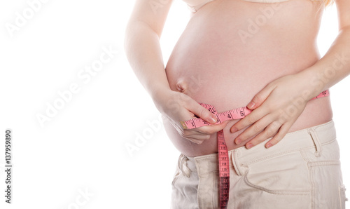 Lovely pregnant woman measuring belly. Uneventful pregnancy. Man is unrecognizable.