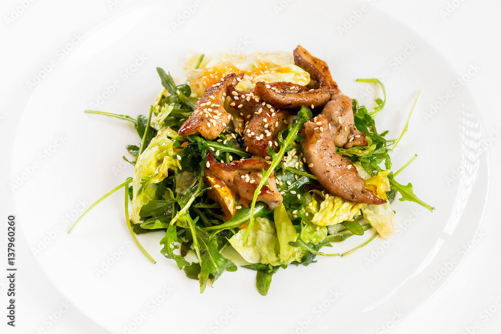 Closeup image of roasted duck at plate with green salad isolated at white background. Closeup image of roasted duck at plate with green salad isolated at white background.