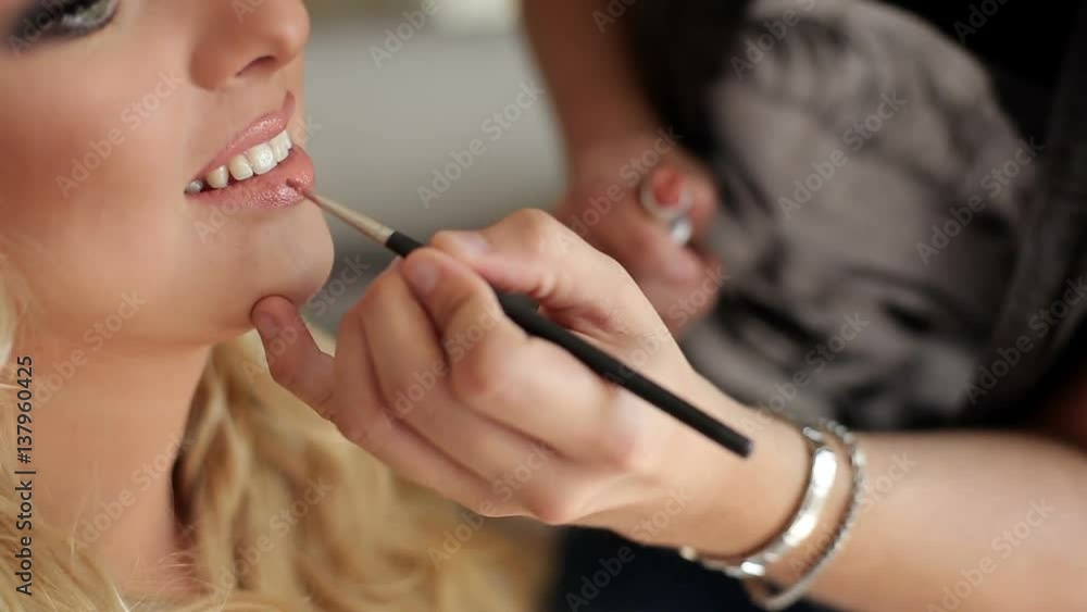Makeup artist doing makeup for young blonde caucasian woman Makeup artist doing makeup for young blonde caucasian woman