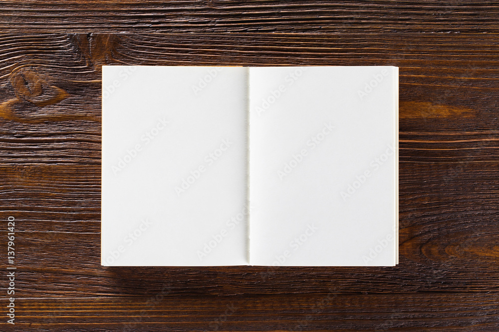 Mockup of opened blank book at brown wooden table background. Mockup of opened blank book at brown wooden table background.