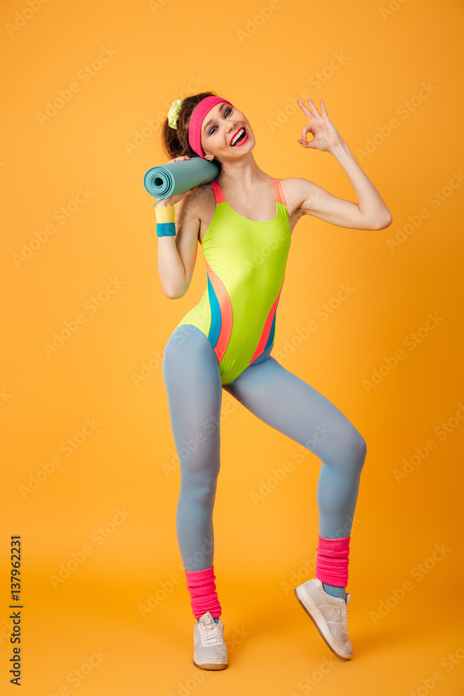 Pretty young sports woman posing over yellow background Pretty young sports woman posing over yellow background