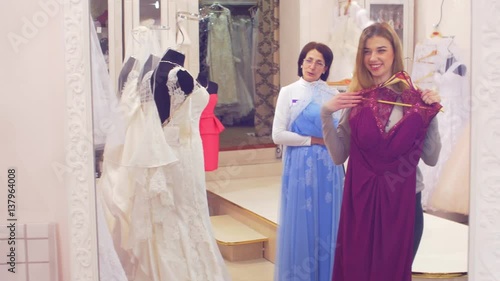 Girl helps to choose a dress for bridesmaids photo