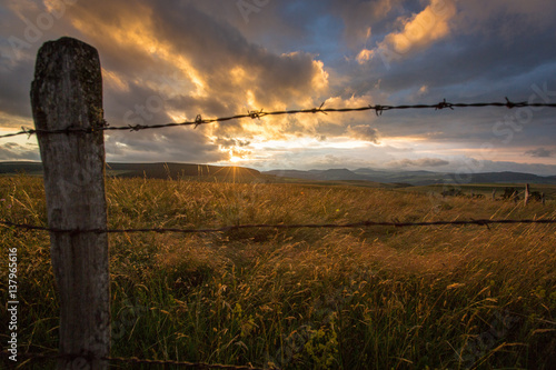 Old barbed wire fence and a colorful sunset