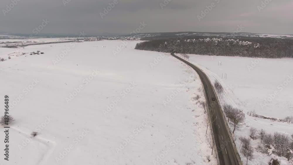 aerial view of road through winter forest with frosty trees
aerial view of road through winter forest with frosty trees