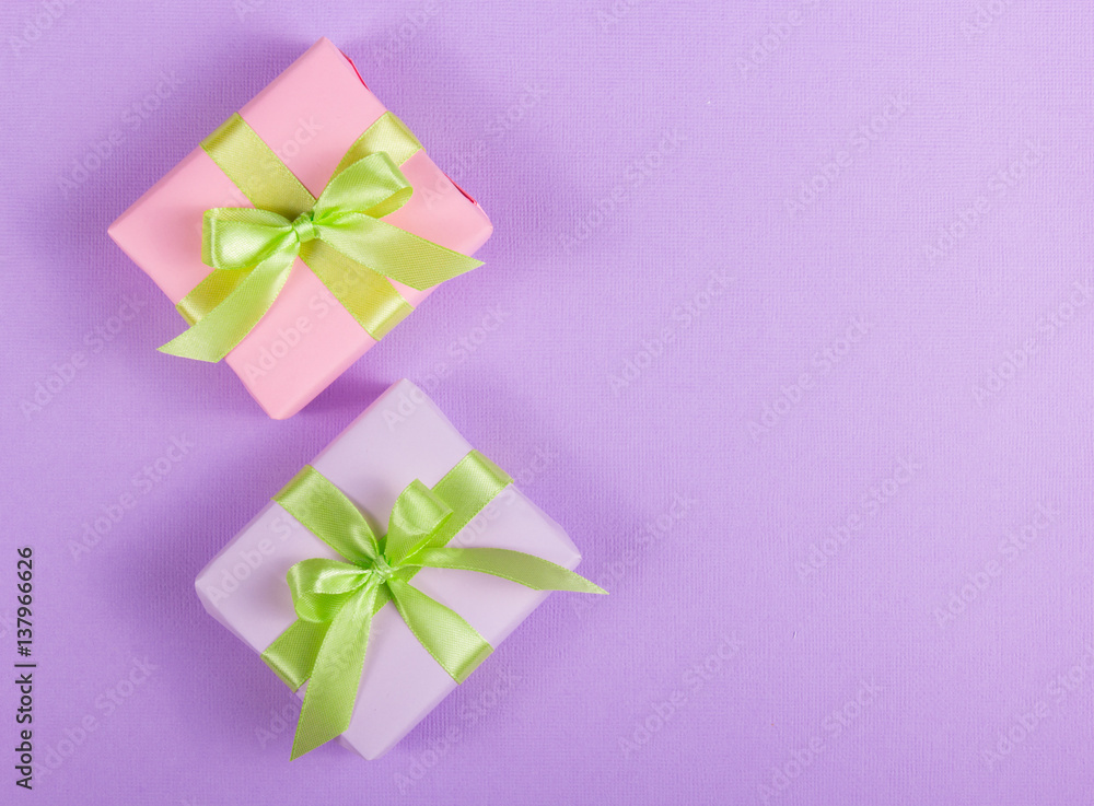 Two little gift box with a bow on a purple background. Copy space