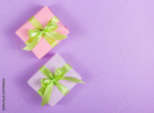 Two little gift box with a bow on a purple background. Copy space