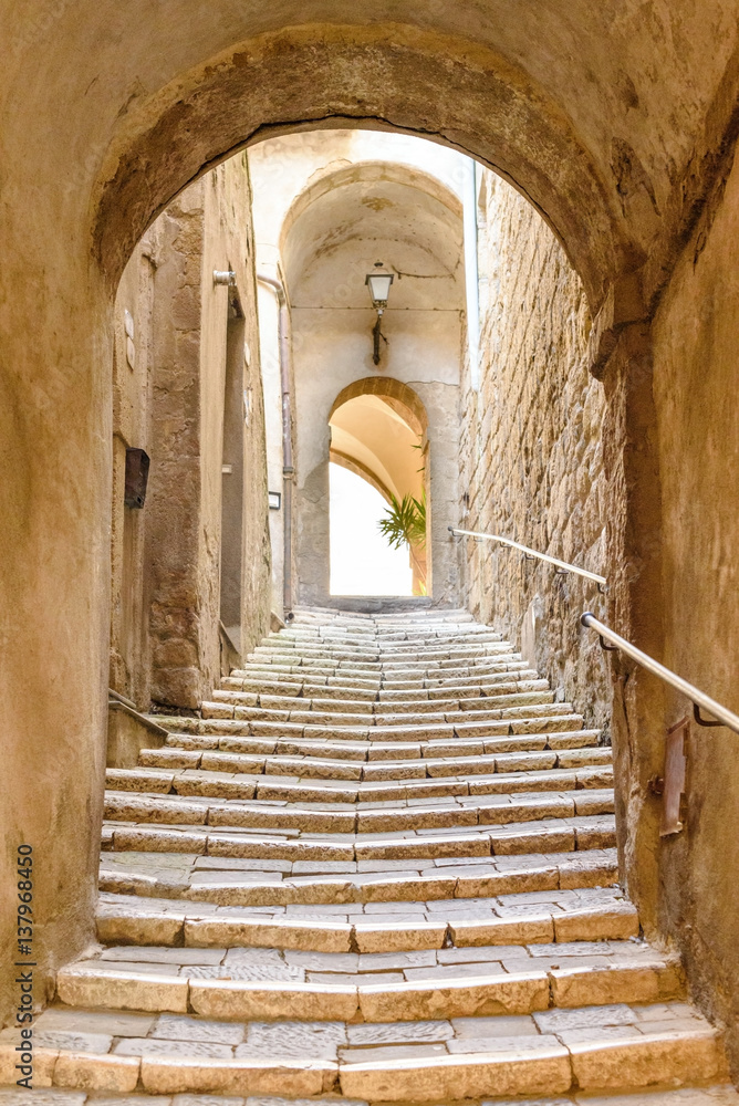 Fototapeta premium stare kamienne schody i łuk w średniowiecznej wiosce, Pitigliano, Toskania, Włochy