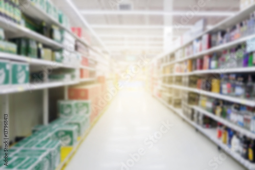 Abstract blurred supermarket aisle with colorful shelves and unrecognizable customers as background © nonnie192