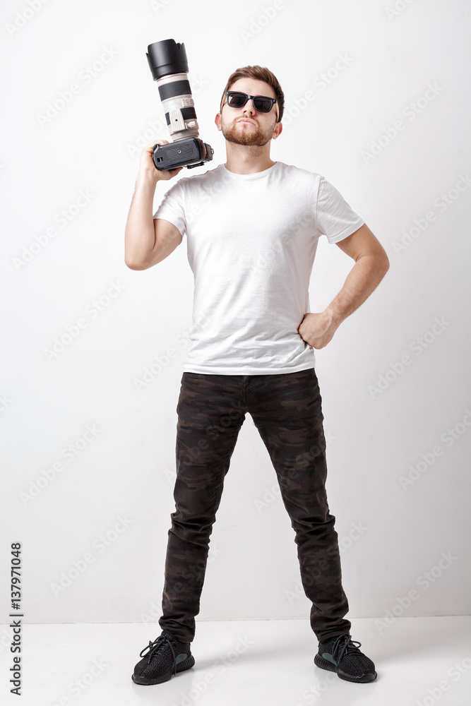 professional photographer in t-shirt use digital camera with lon professional photographer in t-shirt use digital camera with lon