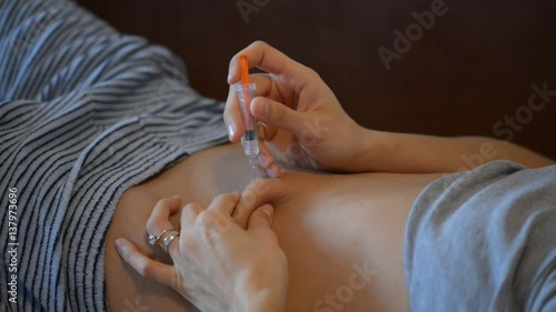 Female hands inject drugs in the stomach