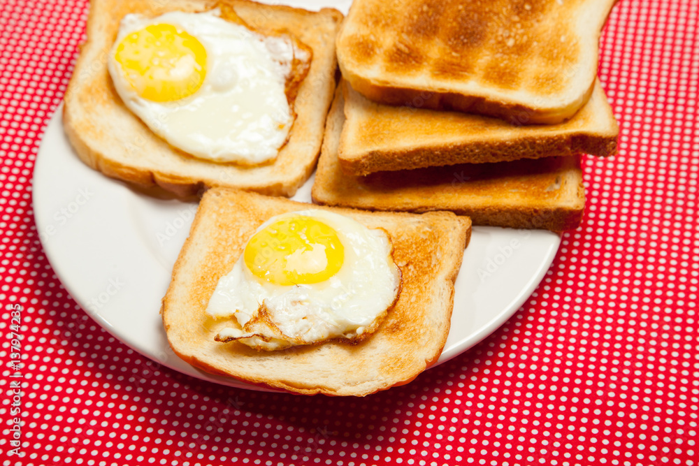Toasts and eggs on a plate on a red table Toasts and eggs on a plate on a red table