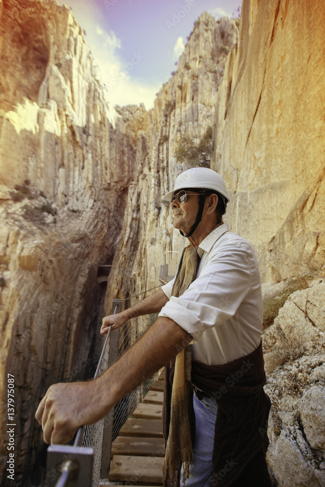 adventurous man with helmet appreciating a cliff on a mountain expedition adventurous man with helmet appreciating a cliff on a mountain expedition