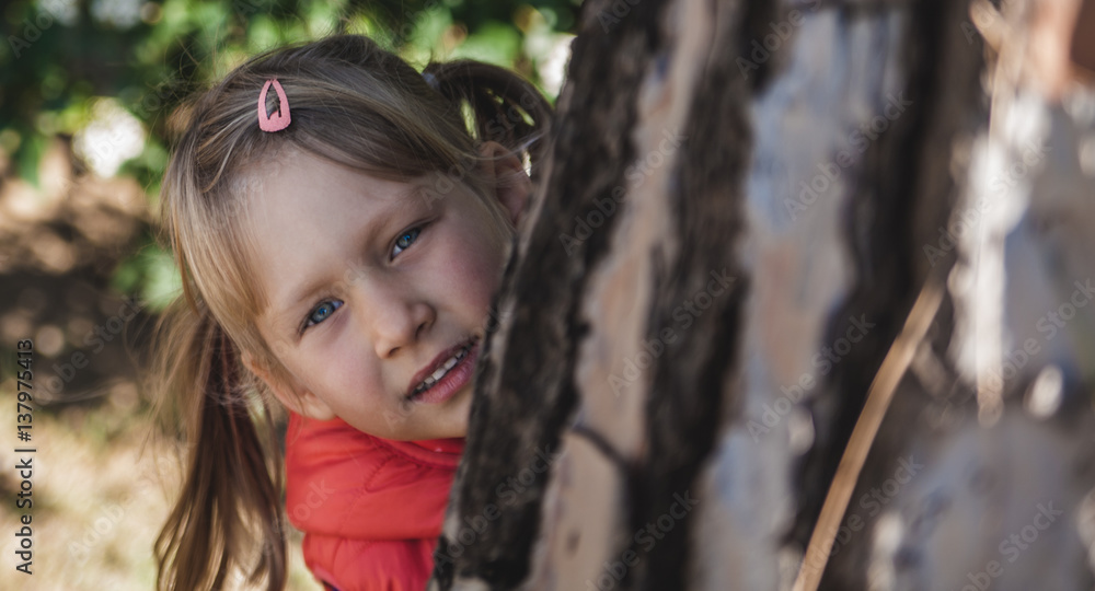 Little pretty girl with blue eyes in a red vest in the park Little pretty girl with blue eyes in a red vest in the park