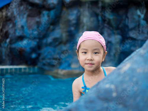 Fotografía Asian girl is playing in the pool, peekaboo action