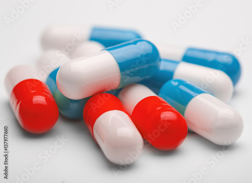 pile of medical pills and blue pills on a background