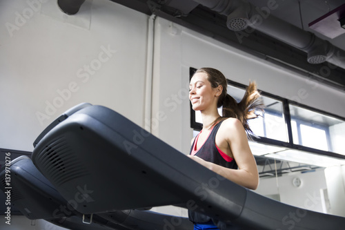 Young woman exercise on the treadmill at the gym photo