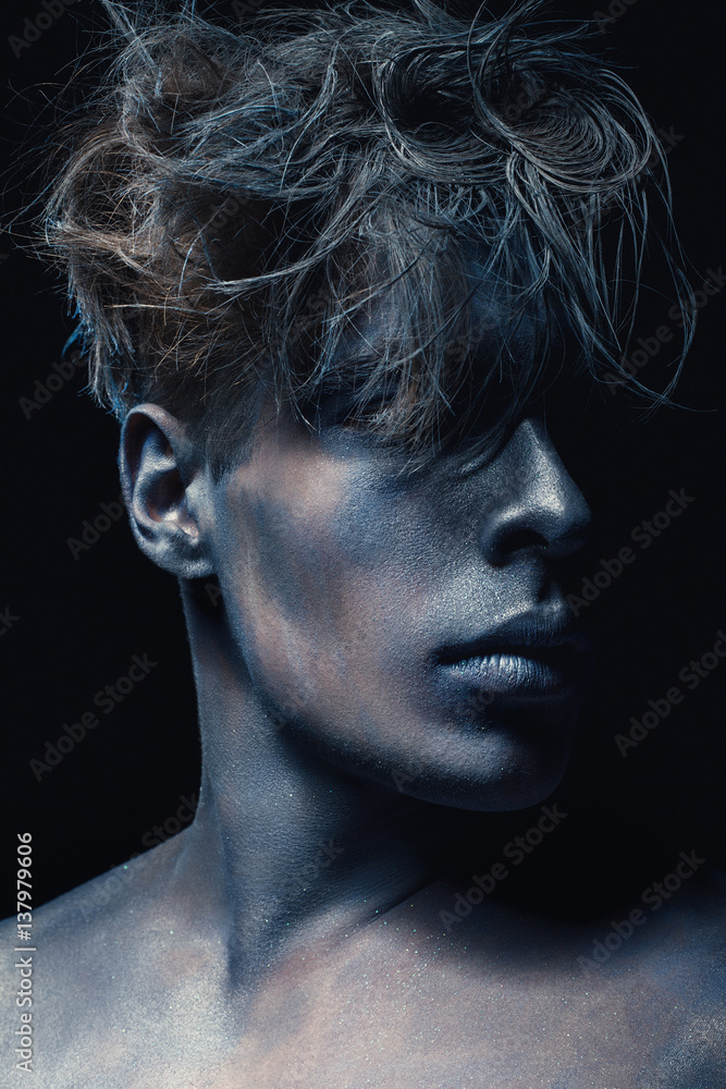 Beauty style portrait of guy isolated at dark background. Art blue and grey Makeup. Hairstyle and skincare concept. 