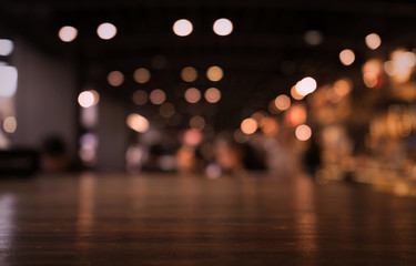 Empty wood table top on blur light gold bokeh of cafe restaurant in dark background/selective focus.
