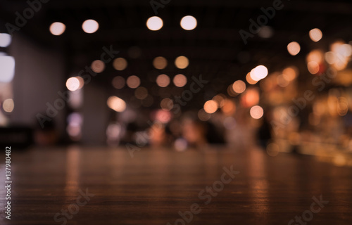 Empty wood table top on blur light gold bokeh of cafe restaurant in dark background/selective focus. © hakinmhan