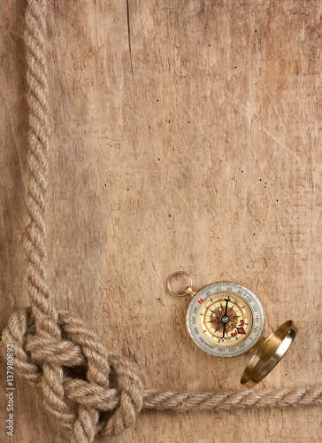 compass and rope on a wooden background