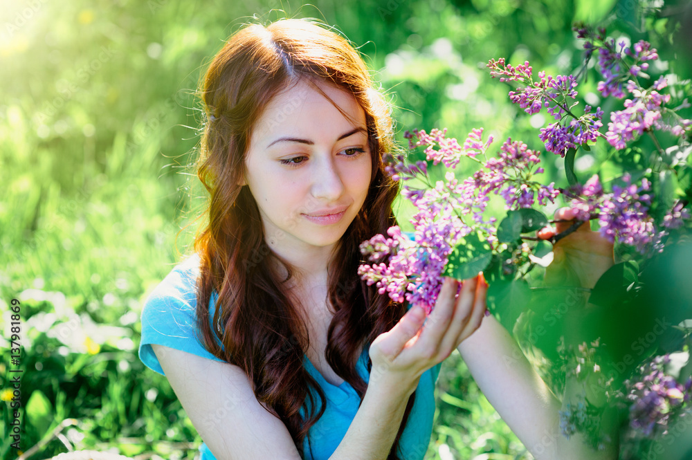 young woman near the lilac bush in the spring park young woman near the lilac bush in the spring park