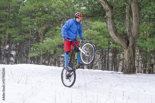 Cyclist on the mountain bike, extreme winter riding in the forest.