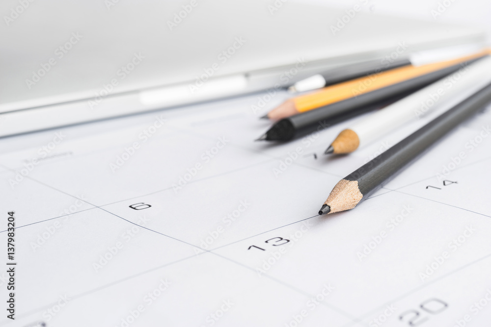 Selective focus of pen pencil and notebook on calender Selective focus of pen pencil and notebook on calender