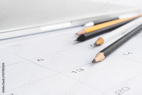 Selective focus of pen pencil and notebook on calender