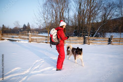 Young woman with dog. Winter outdoors fun. Woman hiking with dog, walking and trekking in cold white nature