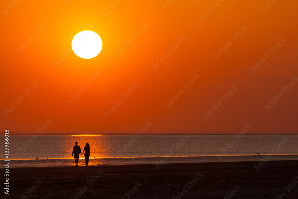 Fototapeta premium Liebes Paar beim Sonnenuntergang am Strand