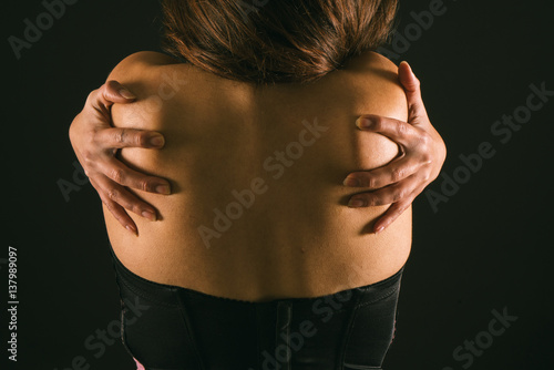 espalda de una mujer latina con las manos en los homoplatos