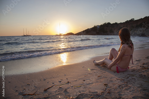 romantic woman staring at the sunset isolated on the beach