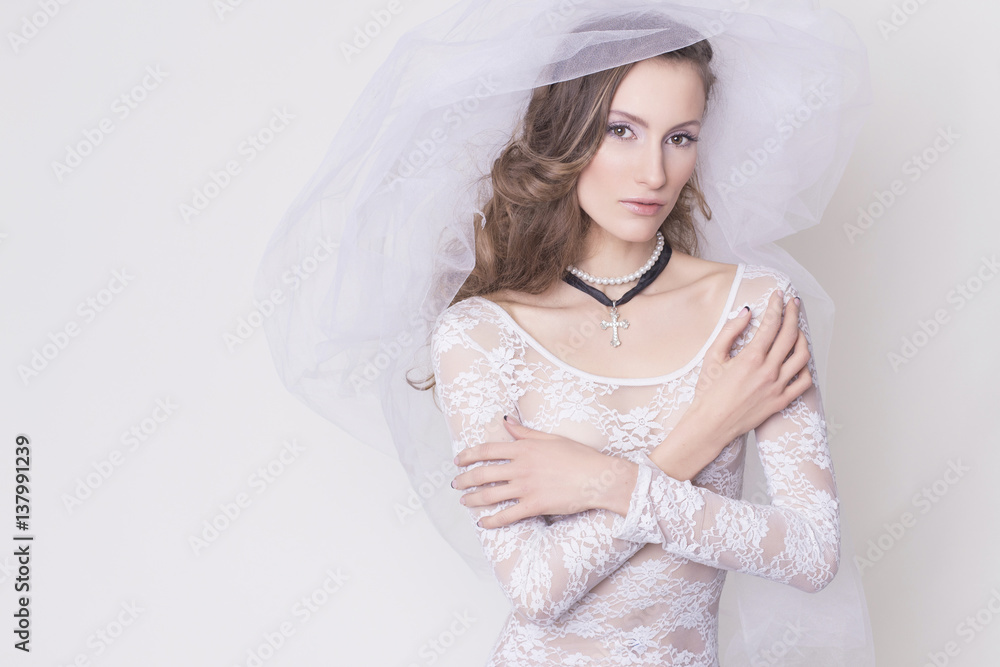 Brunette bide innocent nun woman in lace dress with a veil with a cross accessories, all wearing white. sensual portrait Brunette bide innocent nun woman in lace dress with a veil with a cross accessories, all wearing white. sensual portrait