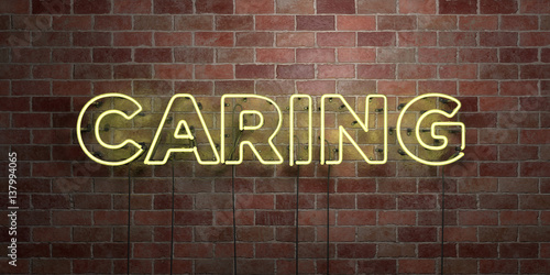 CARING - fluorescent Neon tube Sign on brickwork - Front view - 3D rendered royalty free stock picture. Can be used for online banner ads and direct mailers..